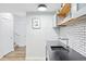 Basement bar area with stylish subway tile backsplash, modern shelving, and a clean, open layout at 5984 Fulton St, Denver, CO 80238