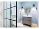Modern bathroom featuring a stylish vanity, round mirror, and glass-enclosed shower with black trim at 5984 Fulton St, Denver, CO 80238