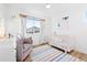 Well-lit Bedroom features a crib, glider, and playful decor, perfect for a serene space at 5984 Fulton St, Denver, CO 80238