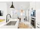 Well-lit kitchen and dining area with modern appliances, a large island, and a view to the backyard at 5984 Fulton St, Denver, CO 80238