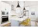 Well-lit kitchen features stainless steel appliances, a large island with seating, and modern cabinetry at 5984 Fulton St, Denver, CO 80238