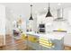 Spacious kitchen features stainless steel appliances, pendant lighting, a large island, and an adjacent dining area at 5984 Fulton St, Denver, CO 80238