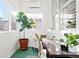 Bright sunroom with green tile flooring, potted plants, a desk, and ample natural light at 5984 Fulton St, Denver, CO 80238