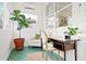 Cozy sunroom featuring green tiled floors, a desk, a chair, and a large potted plant at 5984 Fulton St, Denver, CO 80238