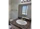 Bathroom with a granite countertop, vanity, and a window at 16180 E Flora Pl, Aurora, CO 80013