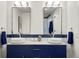 Modern bathroom featuring double sinks with white countertops and navy blue cabinets at 1763 S Williams St, Denver, CO 80210