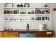 Custom built-in bookshelf with beautiful decor and wood detailing above a bar at 1763 S Williams St, Denver, CO 80210