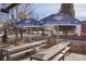 Outdoor seating area with picnic tables under Denver Beer Co. branded umbrellas with street views at 1763 S Williams St, Denver, CO 80210