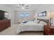 Bedroom featuring a bed facing the window, ceiling fan and dresser at 17213 W 93Rd Pl, Arvada, CO 80007