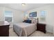 Cozy bedroom with an ornate bed, dresser, and a pleasant view from the windows at 17213 W 93Rd Pl, Arvada, CO 80007