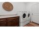 Well-equipped laundry room featuring modern washer and dryer set, cabinet, countertop, and stylish decor at 17213 W 93Rd Pl, Arvada, CO 80007