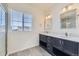 Bathroom featuring double vanities, a window, and modern fixtures at 14074 Yellow Tip Dr, Parker, CO 80134