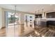 Bright open floor plan, with dark kitchen island and wood floors, flows into the living room and patio at 14074 Yellow Tip Dr, Parker, CO 80134
