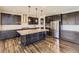 Modern kitchen featuring dark wood cabinetry, granite countertops, stainless steel appliances, and a large center island at 14074 Yellow Tip Dr, Parker, CO 80134