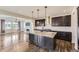 Open-concept kitchen with a granite island, pendant lighting, stainless steel appliances, and wood floors; stylish and functional at 14074 Yellow Tip Dr, Parker, CO 80134