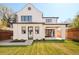 Two-story home with a white facade and a backyard featuring lush green grass and modern patio at 535 Albion St, Denver, CO 80220