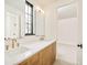 Bright bathroom featuring a dual sink vanity with a white countertop and wood cabinets plus modern fixtures at 535 Albion St, Denver, CO 80220