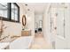 Bright bathroom features a modern standalone tub, stylish fixtures, and shower with glass doors at 535 Albion St, Denver, CO 80220