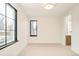 Bright, empty bedroom with neutral carpet, modern black trimmed window, and an attached bath at 535 Albion St, Denver, CO 80220