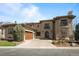 This two-story home showcases a tile roof, a wooden garage door, and mature landscaping at 9099 E Harvard Ave, Denver, CO 80231