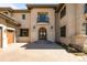 Up close, the home reveals a striking wood front door and an attached two-car garage at 9099 E Harvard Ave, Denver, CO 80231
