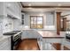 Gourmet kitchen with stainless steel appliances, custom cabinetry, and center island with wood countertop at 9099 E Harvard Ave, Denver, CO 80231