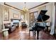A living room featuring a fireplace, wood floors, a chandelier, and a grand piano at 9099 E Harvard Ave, Denver, CO 80231