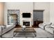 Comfortable living room showcasing a fireplace, display cabinet, and hardwood floors with area rug at 9099 E Harvard Ave, Denver, CO 80231