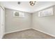 Clean basement featuring neutral carpeting and two windows that provide natural light into the space at 6614 Everett St, Arvada, CO 80004