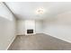 Neutral carpeted basement features a window for natural light and a classic white-tiled fireplace at 6614 Everett St, Arvada, CO 80004