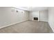 Spacious basement featuring neutral carpeting, a window for natural light, and a classic white-tiled fireplace at 6614 Everett St, Arvada, CO 80004