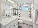 Bright bathroom featuring a tub with white subway tile and a white marble countertop on the vanity at 6614 Everett St, Arvada, CO 80004