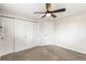 Bedroom with neutral walls, carpet, ceiling fan, closet and a door to either the hallway or another bedroom at 6614 Everett St, Arvada, CO 80004