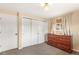 Bedroom featuring carpeted floors, windows, and a dresser with lots of drawers at 6614 Everett St, Arvada, CO 80004
