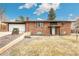Charming brick home featuring an attached garage and mature landscaping at 6614 Everett St, Arvada, CO 80004