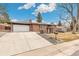 Beautiful brick home with a spacious driveway and well-manicured front lawn at 6614 Everett St, Arvada, CO 80004