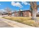 Charming brick home with a well-manicured lawn and mature trees in a suburban setting at 6614 Everett St, Arvada, CO 80004