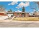 Traditional brick house with an attached garage, complemented by a tidy front yard at 6614 Everett St, Arvada, CO 80004