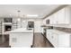 Bright kitchen with white cabinets, quartz countertops, stainless steel appliances, and a gray backsplash at 6614 Everett St, Arvada, CO 80004