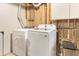 Basement laundry room featuring modern white washer and dryer units, and storage at 6614 Everett St, Arvada, CO 80004
