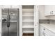 A spacious pantry with white shelving located next to the stainless steel refrigerator at 6614 Everett St, Arvada, CO 80004