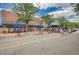 Charming street view with outdoor seating, shops and trees lining the road at 6614 Everett St, Arvada, CO 80004