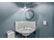 Charming bathroom featuring a vintage corner sink, round mirror, and blue wall at 3015 Lowell Blvd, Denver, CO 80211