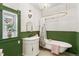 Elegant bathroom with a clawfoot tub, beaded wainscoting, and vintage-style fixtures at 3015 Lowell Blvd, Denver, CO 80211