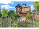 Charming Victorian home with a turret, covered porch, and wrought iron fence, surrounded by lush landscaping at 3015 Lowell Blvd, Denver, CO 80211
