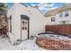 Back exterior with a brick outbuilding, brick planter, white paint and a snow-covered yard at 3015 Lowell Blvd, Denver, CO 80211