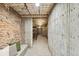Hallway boasts textured walls, tiled floors, with storage shelving, and exposed brick elements at 3015 Lowell Blvd, Denver, CO 80211