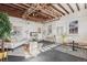 Open living area with exposed brick, whitewashed walls, natural light, and a rustic wooden ceiling at 3015 Lowell Blvd, Denver, CO 80211