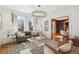 Bright living room featuring a modern chandelier, neutral decor, and a view into the adjacent dining room at 3015 Lowell Blvd, Denver, CO 80211