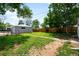 Spacious backyard with detached garage, grassy area, and mature trees at 1180 Newark St, Aurora, CO 80010